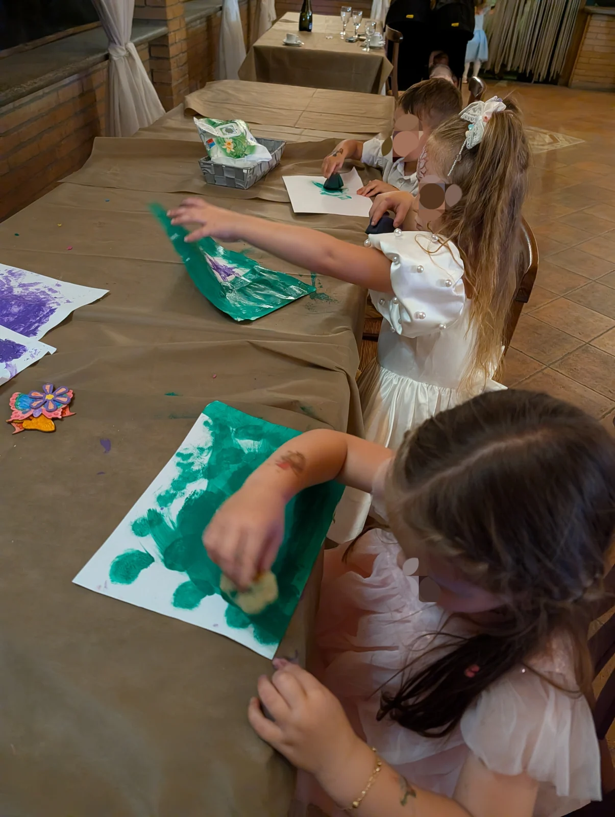 Bambini impegnati in un laboratorio di pittura al tavolo
