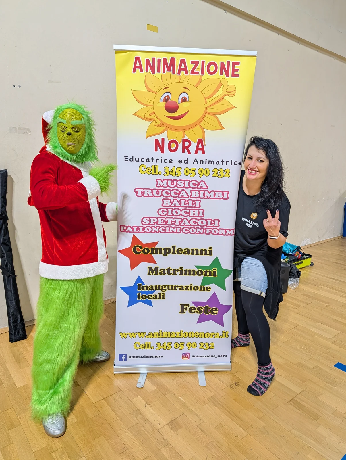Animatrice con mascotte del Grinch accanto al banner Animazione Nora