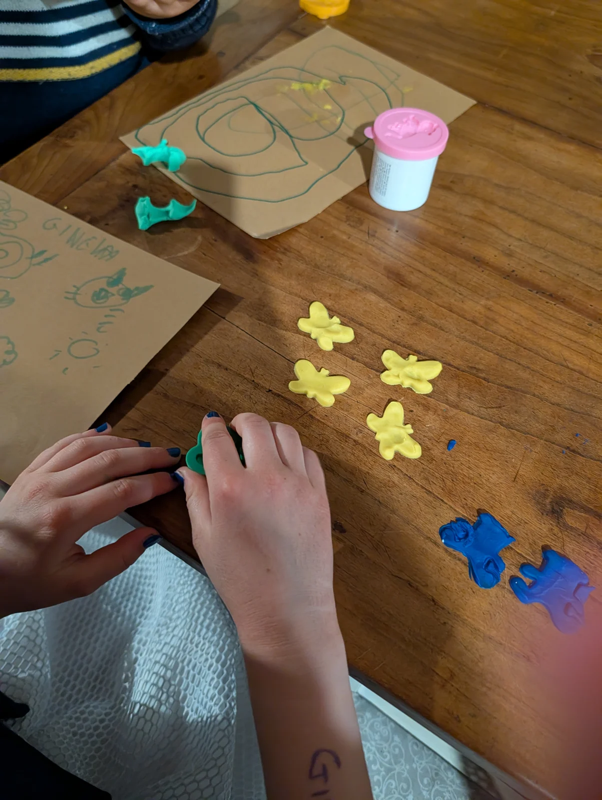 Mani di bambini che creano forme colorate durante un laboratorio